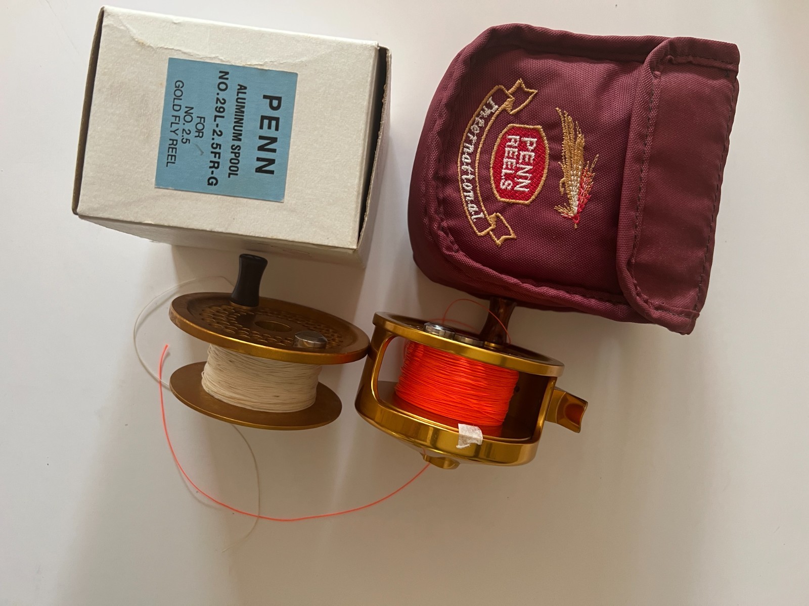 penn international 2.5 gold fly reel with pouch and spare spool.