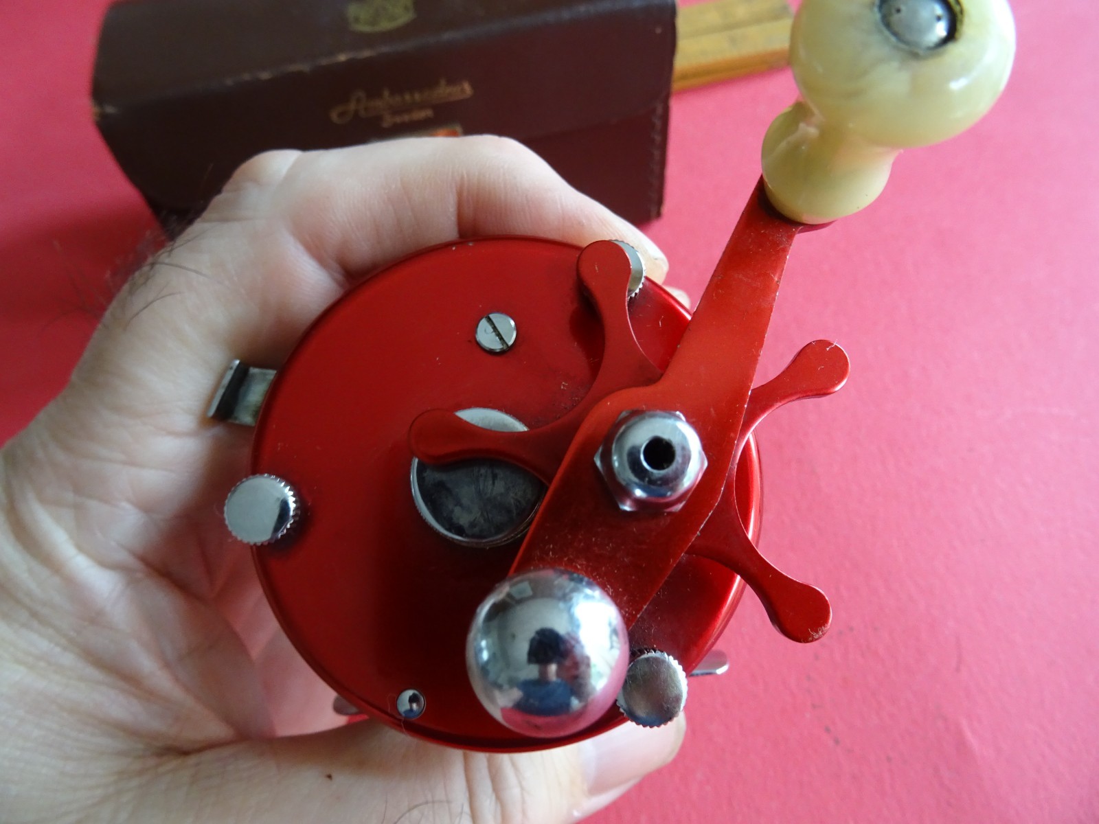 A SUPER CASED VINTAGE 4 SCREW RED ABU AMBASSADEUR 6000 MULTIPLIER REEL