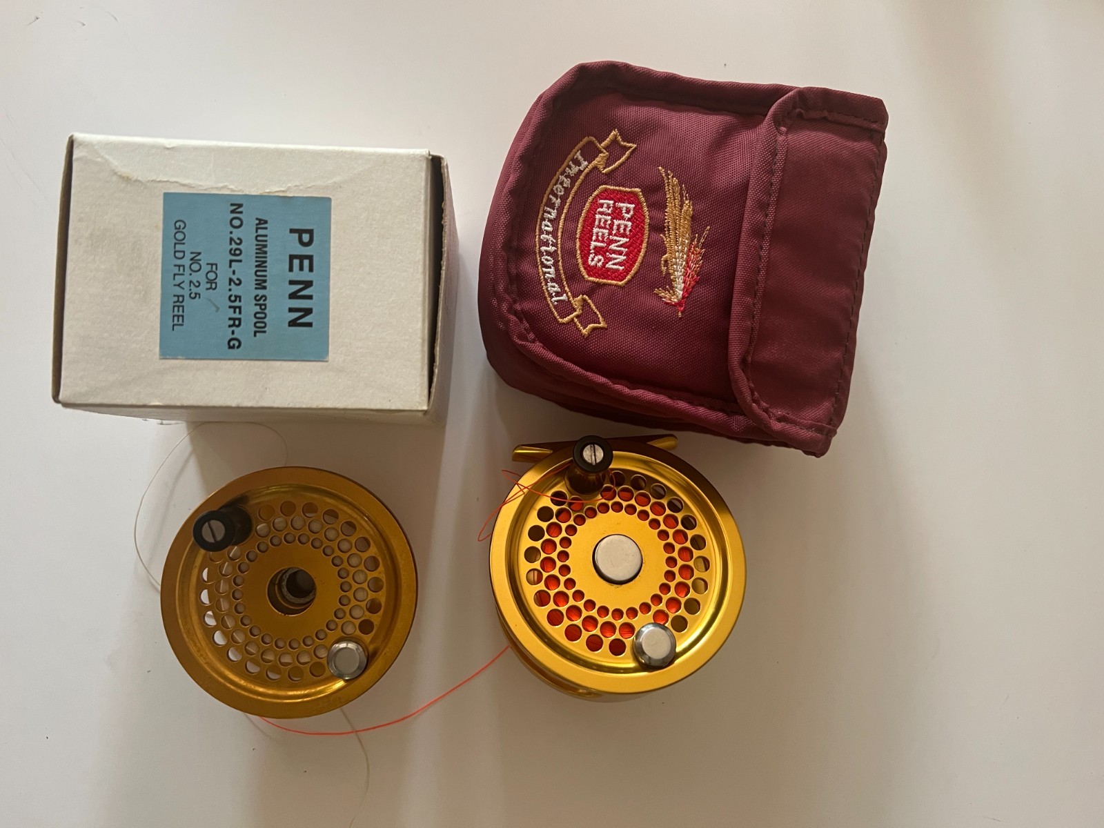 penn international 2.5 gold fly reel with pouch and spare spool.