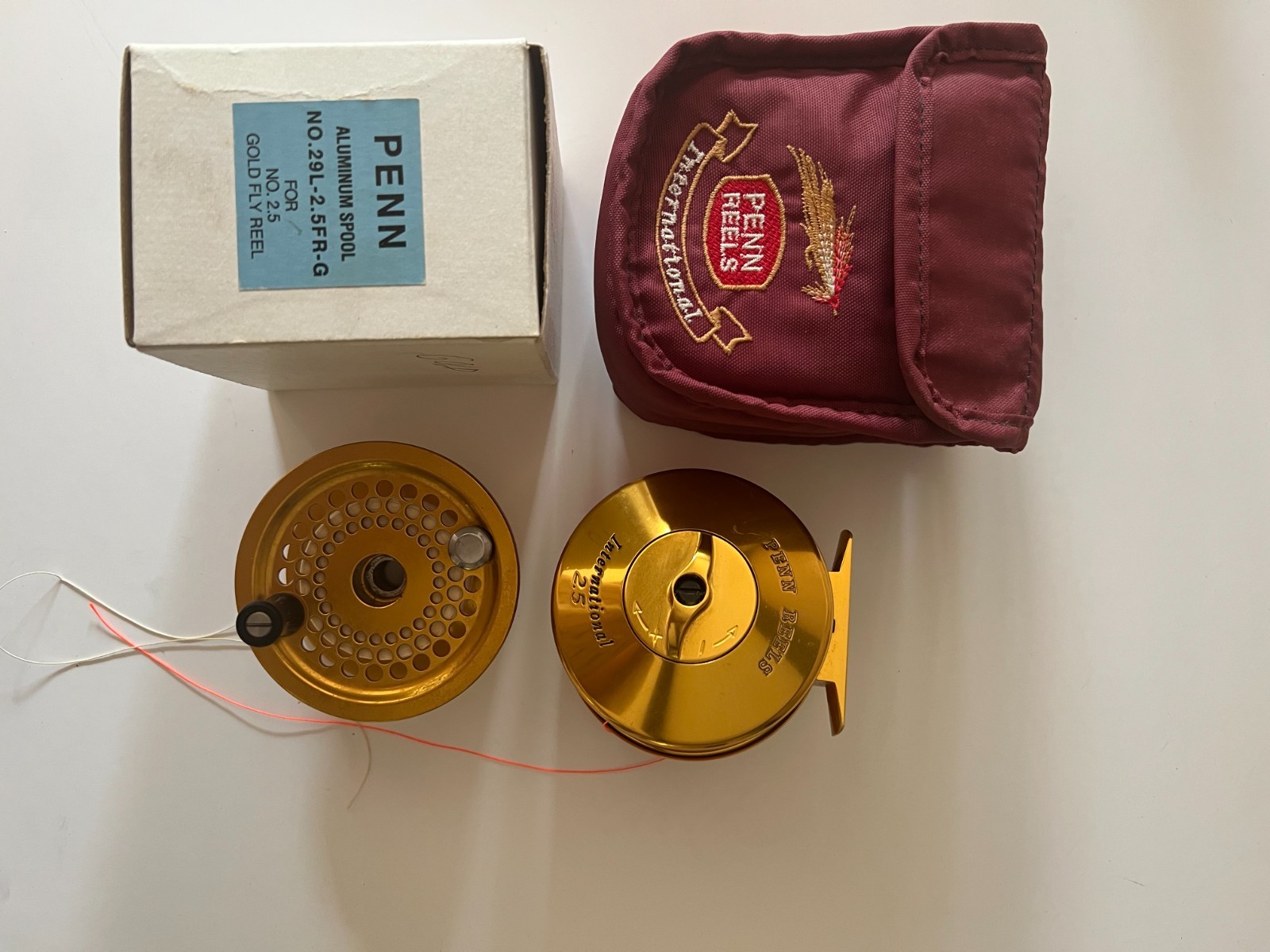 penn international 2.5 gold fly reel with pouch and spare spool.