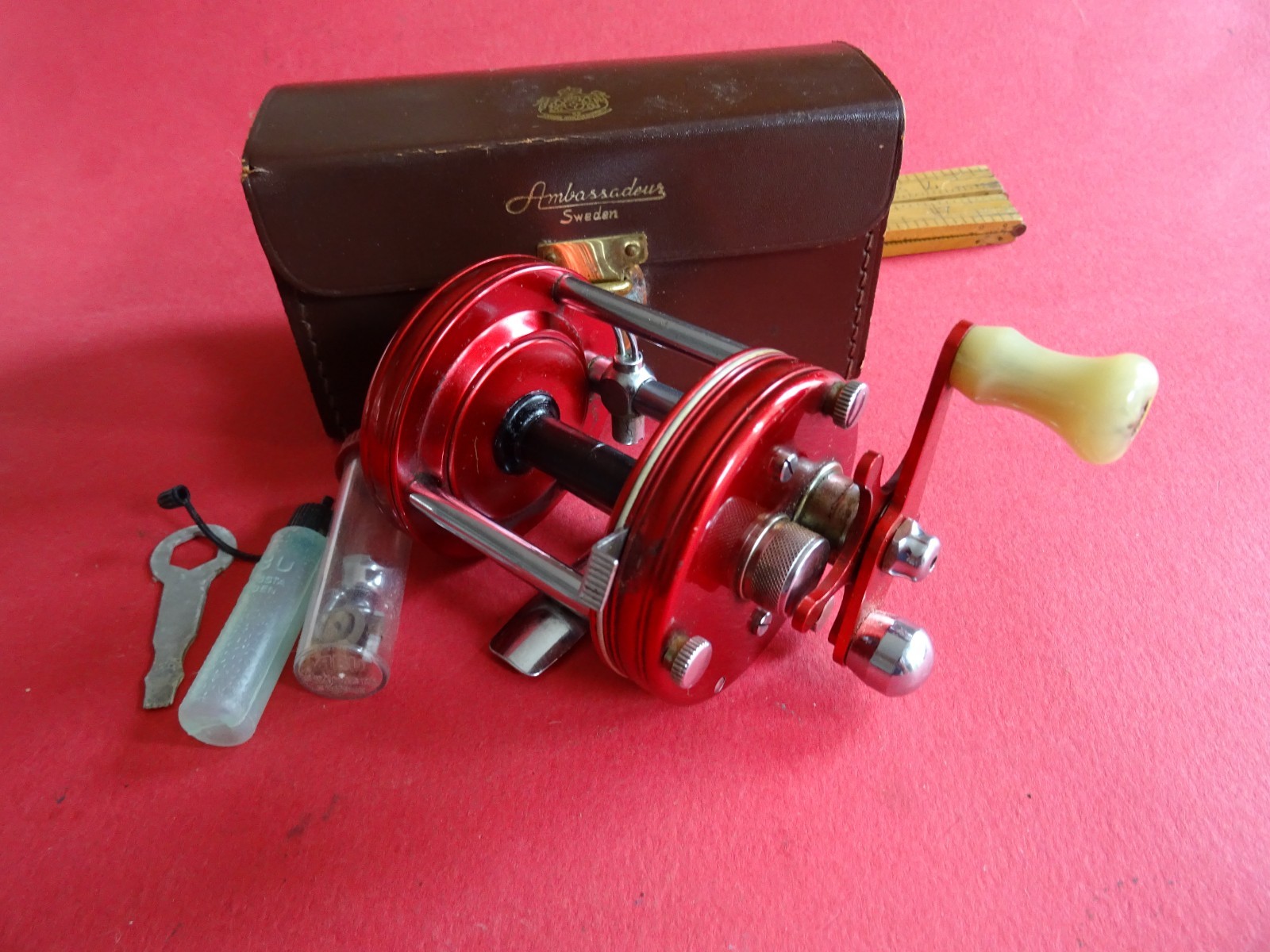 A SUPER CASED VINTAGE 4 SCREW RED ABU AMBASSADEUR 6000 MULTIPLIER REEL